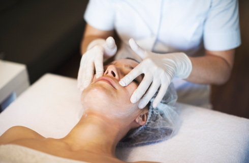 Kosmetyczka w maseczce i rękawiczkach zrobi manicure