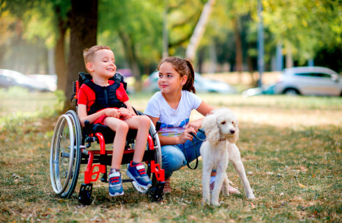 niepelnosprawne dziecko na wozku pies