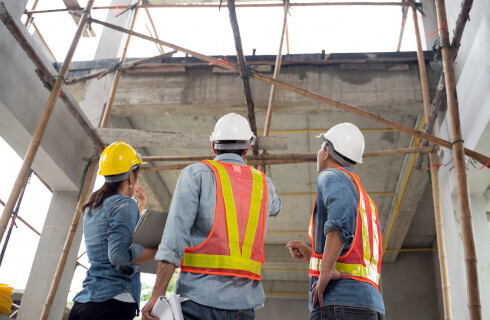 ludzie kaski rusztowanie sciany